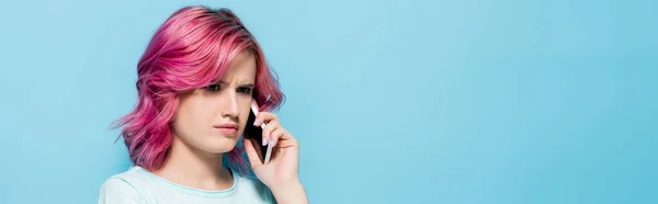 Смущенная Молодая Женщина Розовыми Волосами Говорит Смартфоне Синем Фоне Панорамный — стоковое фото