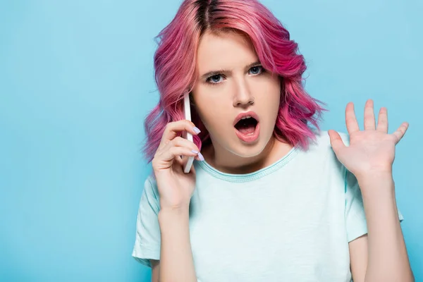 Geschokt Jonge Vrouw Met Roze Haar Praten Smartphone Geïsoleerd Blauw — Stockfoto