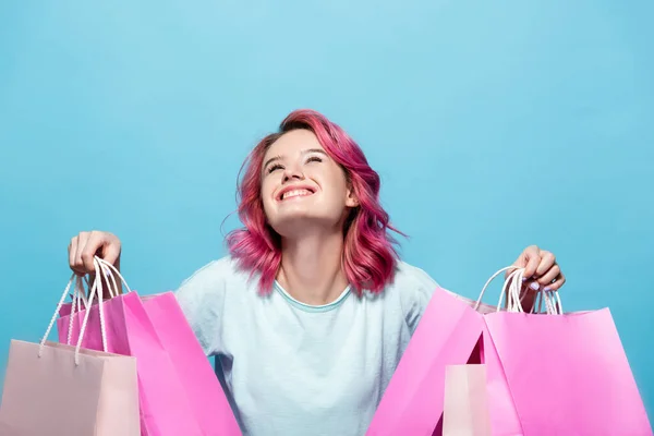 Jonge Vrouw Met Roze Haar Houden Boodschappentassen Glimlachen Geïsoleerd Blauw — Stockfoto