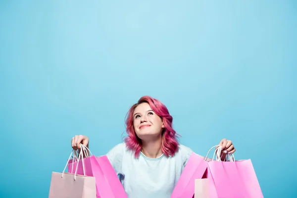 Молодая Женщина Розовыми Волосами Держащая Сумки Покупок Глядя Синий Фон — стоковое фото