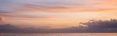 Gün batımında deniz ve bulutlu gökyüzünün panoramik görüntüsü 