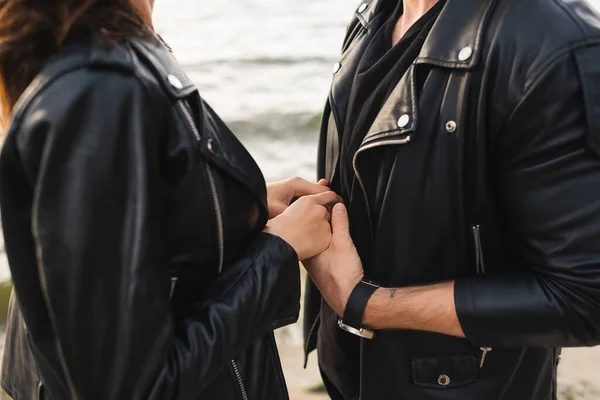 Cropped View Couple Leather Jackets Holding Hands Sea — Stock Photo, Image