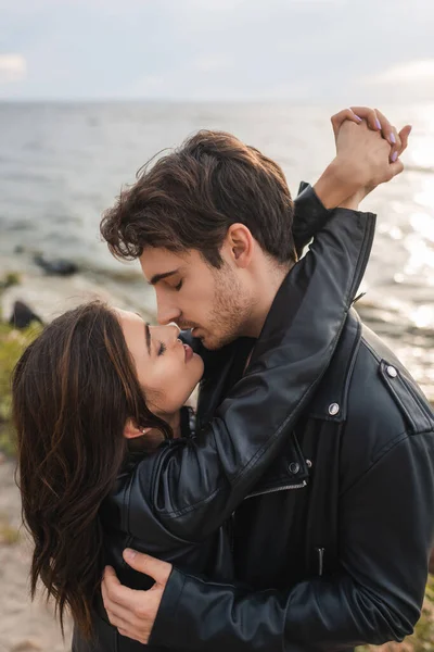 Homem Beijando Abraçando Morena Namorada Jaqueta Couro Praia Mar — Fotografia de Stock