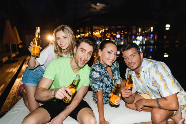 Selective Focus Friends Beer Bottles Looking Camera Outdoors Night — Stock Photo, Image