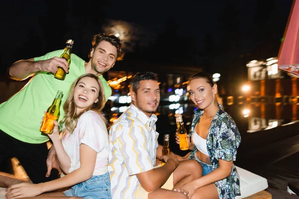 Selective Focus Friends Beer Bottles Looking Camera Outdoors Night — Stock Photo, Image