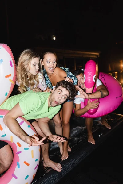 Selective Focus Friends Swim Rings Standing Pool Party Night — Stock Photo, Image