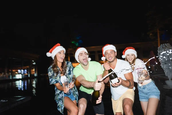 Selective Focus Excited Friends Santa Hats Opening Champagne Pool Night — Stock Photo, Image