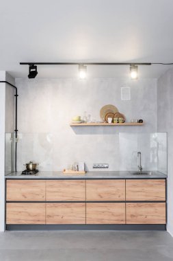 Spacious, minimalistic kitchen with concrete walls clipart