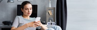 Website header of woman using smartphone at home 