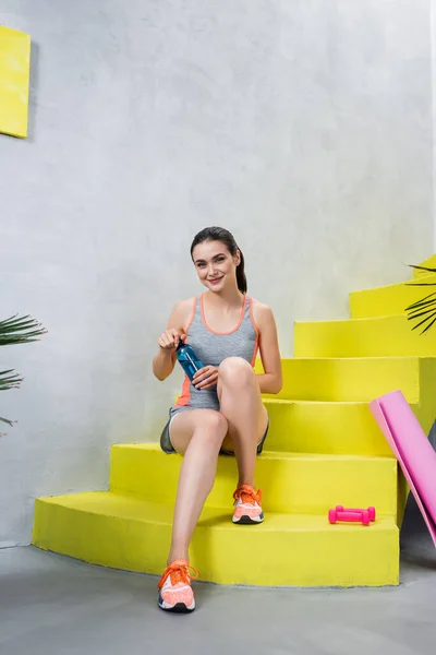 Sportswoman Bottle Sitting Stairs Dumbbells Fitness Mat Home — Stock Photo, Image