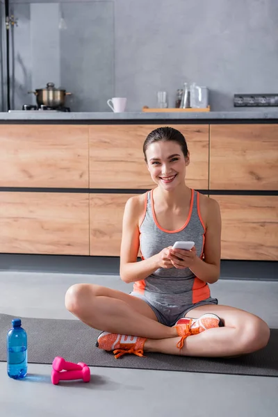 Sportswoman Looking Camera While Holding Smartphone Fitness Mat Water Dumbbells — Stock Photo, Image