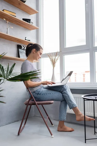 Zijaanzicht Van Barefoot Freelancer Met Behulp Van Laptop Buurt Venster — Stockfoto