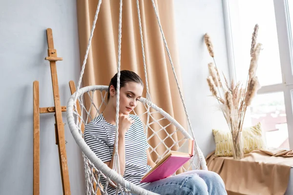 Junge Frau Liest Buch Während Sie Hause Hängenden Sessel Sitzt — Stockfoto