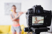 Válogatott fókusz a digitális fényképezőgép közelében sportnő gyakorló otthon 