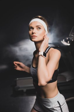 Sporcu kadının seçici odak noktası. Akıllı bakışları spor salonundan uzağa bakıyor.