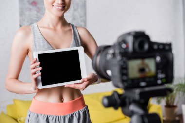 Dijital fotoğraf makinesinin yanında elinde dijital tablet bulunan sporcu görüntüsü 