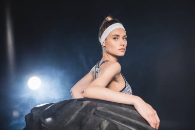 Spor merkezindeki kamera kulak lastiğine dumanla bakan sportmen kadının seçici odağı 