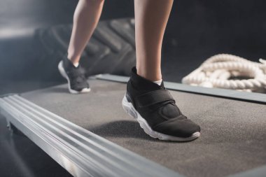 Spor merkezinde koşu bandında egzersiz yapan sporcu kadın manzarası. 