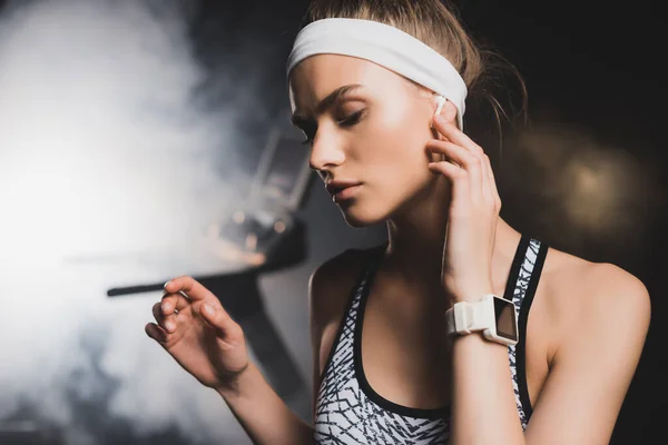 Selective Focus Sportswoman Smartwatch Touching Wireless Earphone Gym — Stock Photo, Image