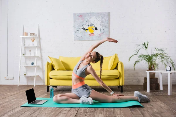 Desportista Com Mão Exercitando Tapete Fitness Perto Laptop Casa — Fotografia de Stock