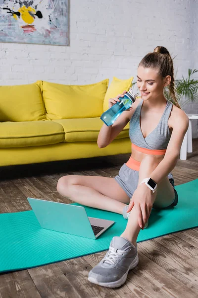Selective Focus Smiling Sportswoman Holding Sports Bottle Looking Laptop Fitness — Stock Photo, Image