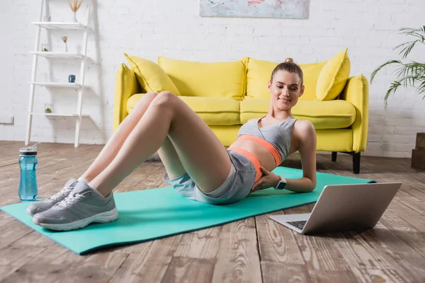 Jonge Vrouw Sportkleding Zoek Naar Laptop Tijdens Training Thuis — Stockfoto