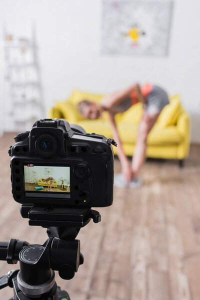 Селективный фокус тренировок молодых спортсменок возле фитнес-коврика и цифровой камеры дома 