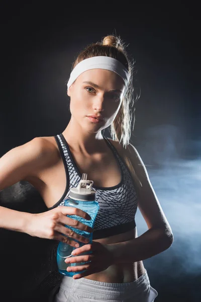 Young Sportswoman Holding Sports Bottle While Looking Camera Gym Smoke — Stock Photo, Image