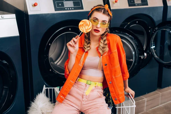 Trendy Woman Sunglasses Holding Lollipop Cart Clothing Washing Machines Laundromat — Stock Photo, Image