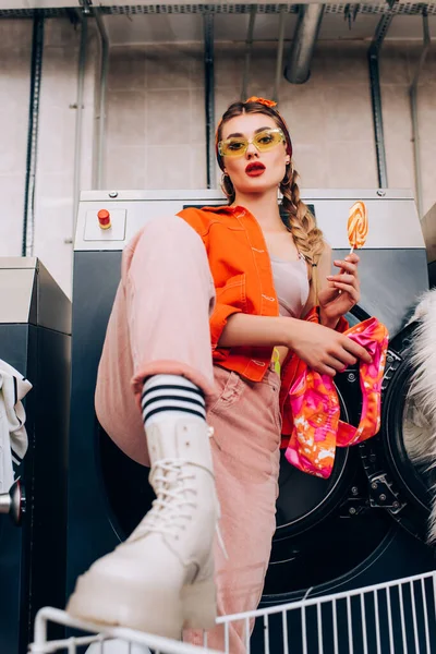 Trendy Young Woman Sunglasses Holding Lollipop Clothing Laundromat Blurred Foreground — Stock Photo, Image