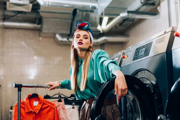 Trendy Woman Turban Standing Clothing Rack Washing Machines Modern Laundromat — Stock Photo, Image