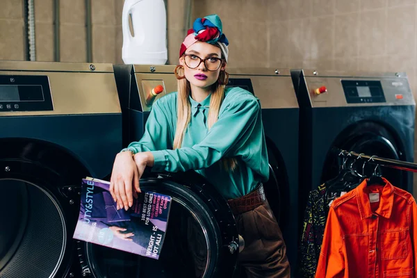 Trendy Woman Glasses Turban Holding Magazine Laundromat — Stock Photo, Image