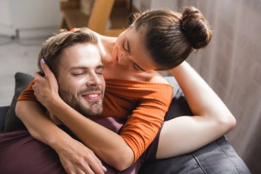 happy man with closed eyes embraced by tender, beloved woman clipart