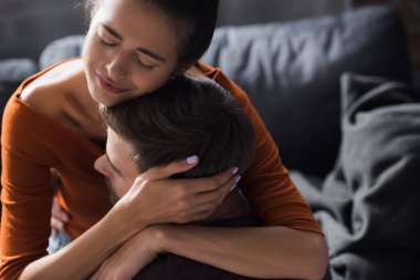 Depresyonda olan kadın, evde ağlarken sevgilisinin başını kucaklıyor.