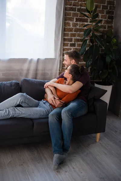 Young Couple Embracing While Resting Sofa Home — Stock Photo, Image