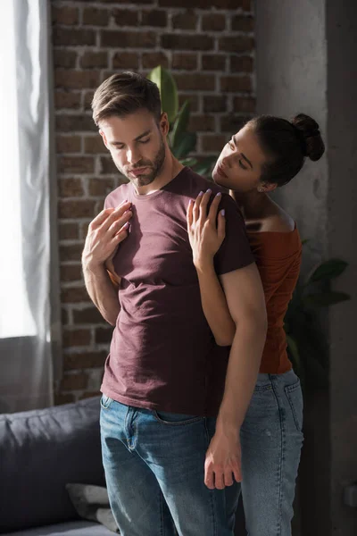 Junge Frau Umarmt Aufgebrachten Mann Von Hinten Während Hause Steht — Stockfoto