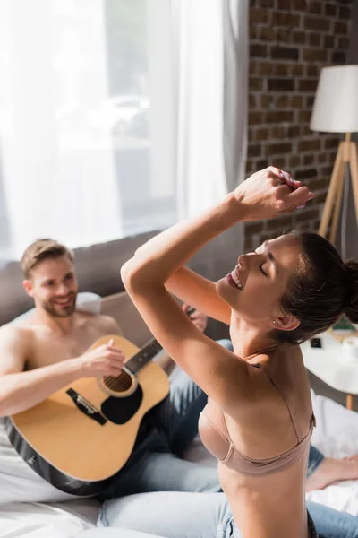 Excited Sexy Woman Dancing Closed Eyes Man Playing Guitar Blurred — Stock Photo, Image
