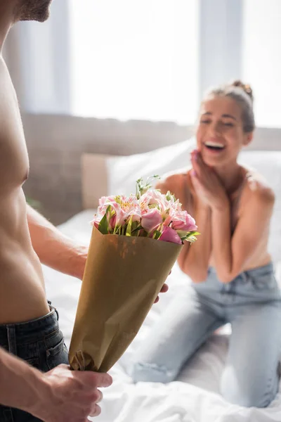 Shirtless Man Holding Bouquet Excited Woman Blurred Background — Stock Photo, Image