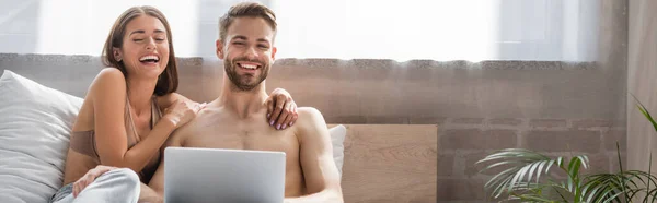 Rindo Mulher Tocando Namorado Sem Camisa Usando Laptop Cama Banner — Fotografia de Stock