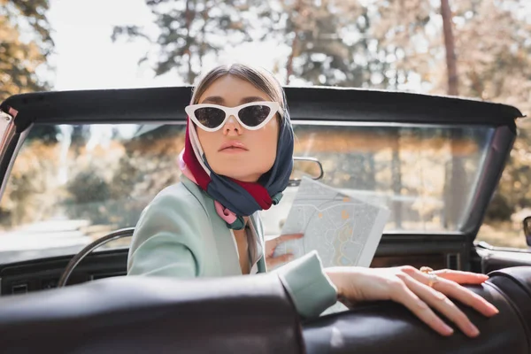 Стильна Жінка Сонцезахисних Окулярах Тримає Карту Ретро Автомобілі Розмитому Передньому — стокове фото