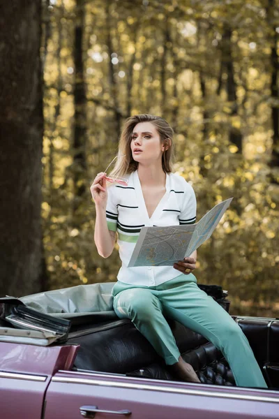Thoughtful Woman Looking Away While Holding Sunglasses Map Convertible Car — Stock Photo, Image