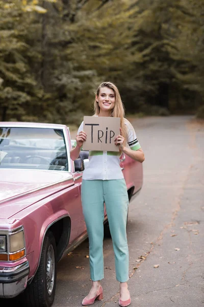 Young Stylish Woman Holding Card Trip Lettering Vintage Convertible Card — Stock Photo, Image