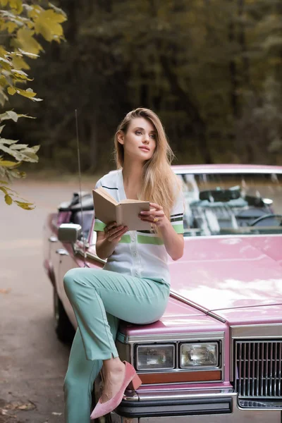 Jovem Mulher Olhando Para Longe Enquanto Sentado Capô Cabriolet Retro — Fotografia de Stock