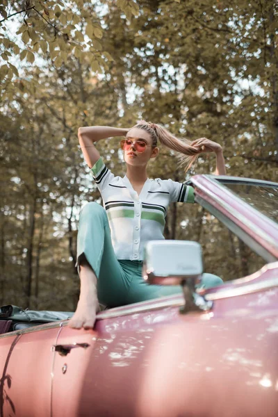 Stijlvolle Barefoot Vrouw Zonnebril Aanraken Van Haar Terwijl Poseren Cabriolet — Stockfoto