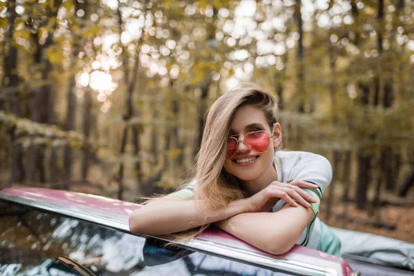 Joyful Woman Sunglasses Looking Camera While Leaning Windshield Cabriolet Crossed — Stock Photo, Image