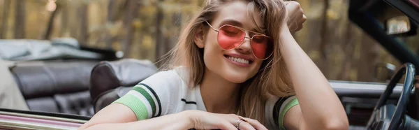 Mujer Sonriente Gafas Sol Sosteniendo Mano Cerca Cabeza Mientras Está — Foto de Stock