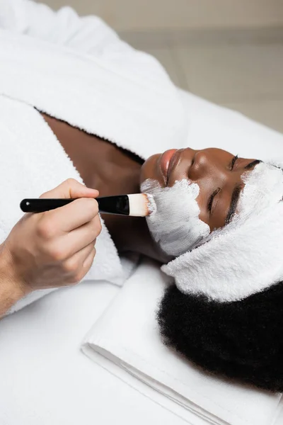 Positive African American Woman Headband Lying Spa Therapist Applying Face — Stock Photo, Image