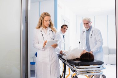Doktorun, meslektaşlarının yanında dijital tablet ve klinikte sedye kullanmasının seçici odağı 