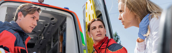 Website header of doctor looking at paramedics near ambulance car outdoors 