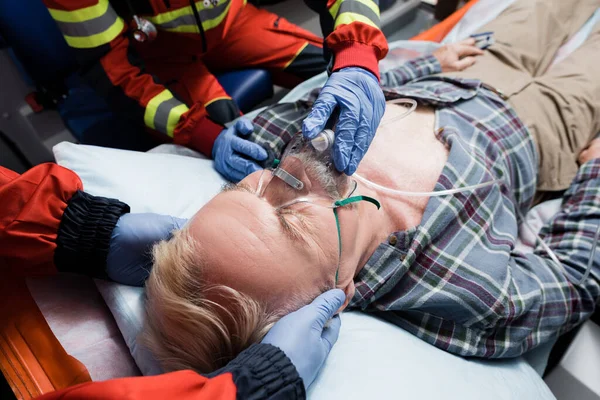 Selective Focus Paramedic Holding Head Patient Colleague Oxygen Mask Ambulance — Stock Photo, Image